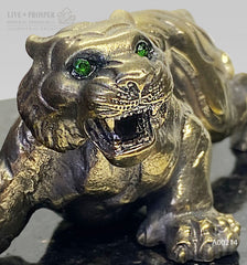 Handmade bronze tiger figure with demantoid inserts and geode's amethyst druzy background at dolerite plate