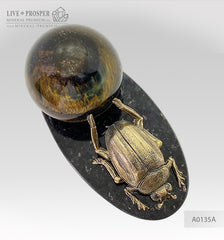 Bronze handmade scarab figure with a tigers’ eyes sphere on a dolerite plate