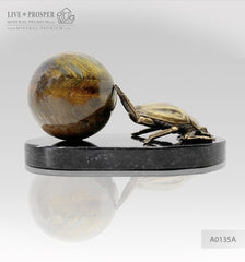 Bronze handmade scarab figure with a tigers’ eyes sphere on a dolerite plate