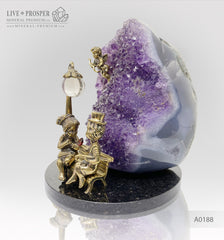Bronze figures of cupid and sweethearts on a bench with a garnet heart on geodes amethyst agate background