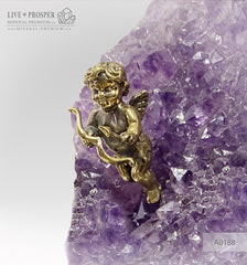 Bronze figures of cupid and sweethearts on a bench with a garnet heart on geodes amethyst agate background