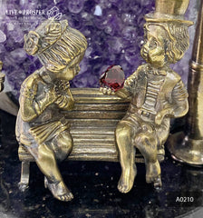 Bronze cupid and sweethearts with garnet heart and geode agate amethyst druzy background on a dolerite plate A0210
